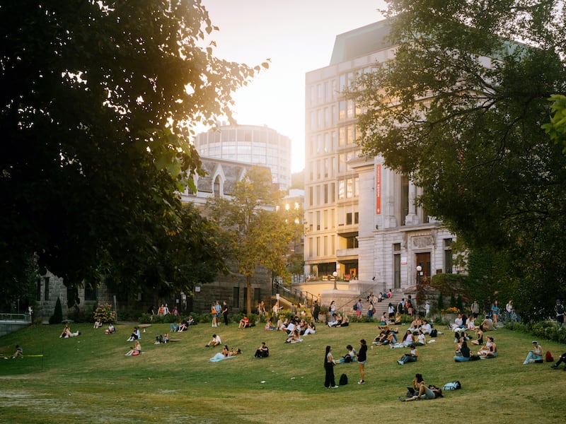 Students relax on the lawn at McGill University in Montreal on Oct. 4, 2023. Montreal has far too much for just 36 hours, but if you bring some good walking shoes, youÕll find terrific meals, stunning views atop Mont-Royal and a creative spirit that comes across in any language. (Clara Lacasse/The New York Times) 