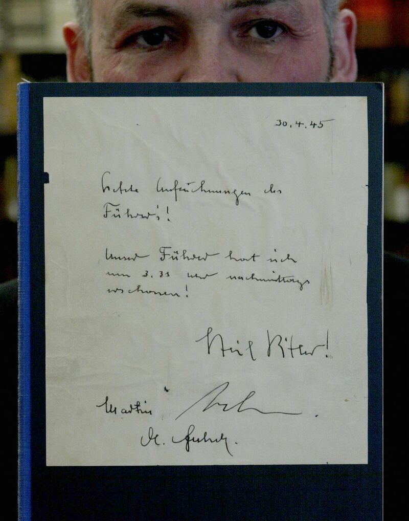 A worker at Berlin auction house Jeschke, Greve and Hauff disposes of a copy of the faked Hitler Diaries by Konrad Kujau. Photograph: Michael Urban/DDP/AFP via Getty