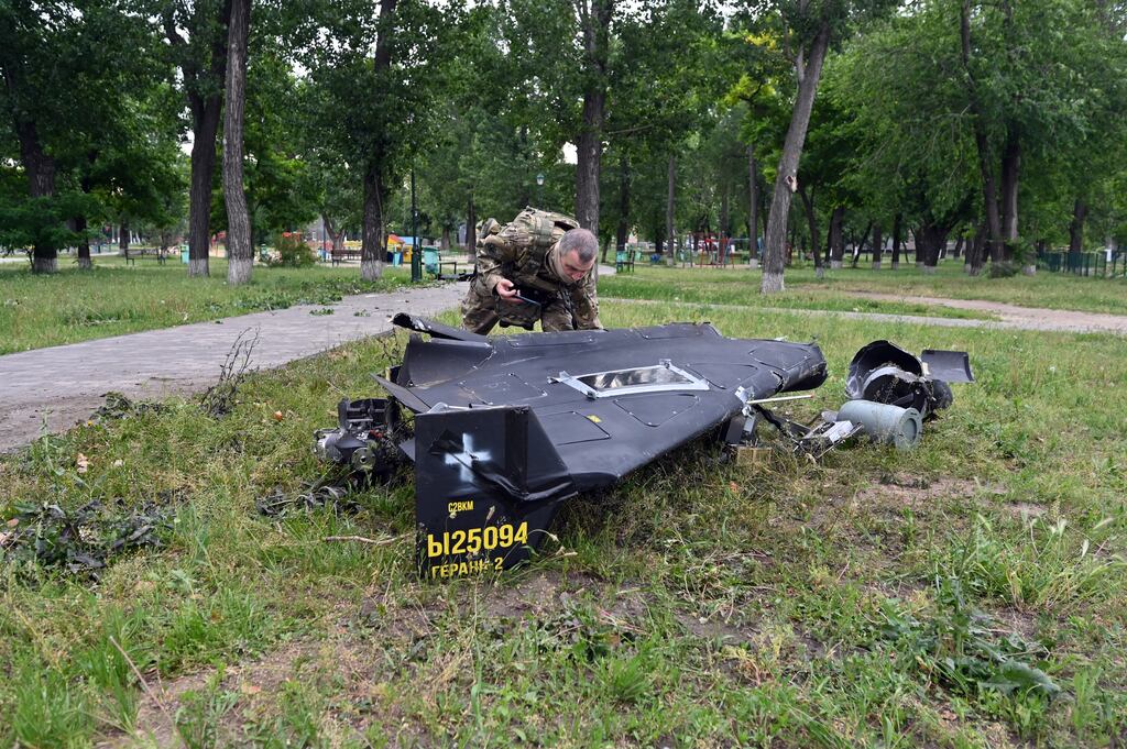 A Ukrainian explosives expert examines parts of a Shahed 136 military drone following an air-attack in Kharkiv. Photograph: Sergey Bobok/AFP via Getty Images