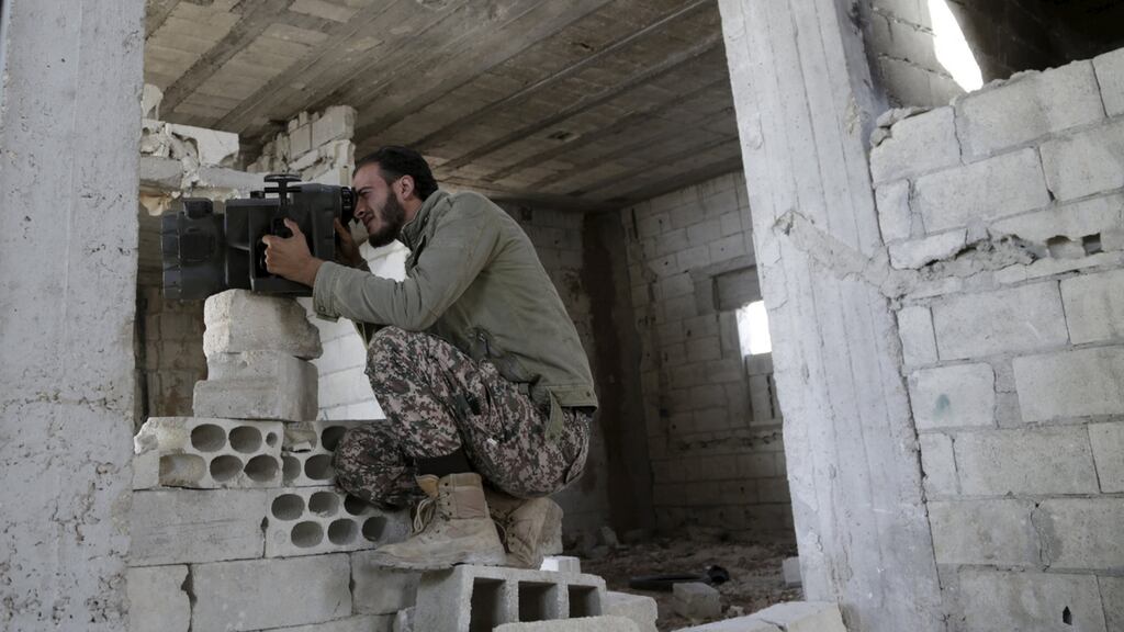 Suheil, a 28-year-old Free Syrian Army fighter of the 101 Division, monitors the movements of forces loyal to Syria’s President Bashar al-Assad in the town of Kafr Nabudah. Photograph: Reuters