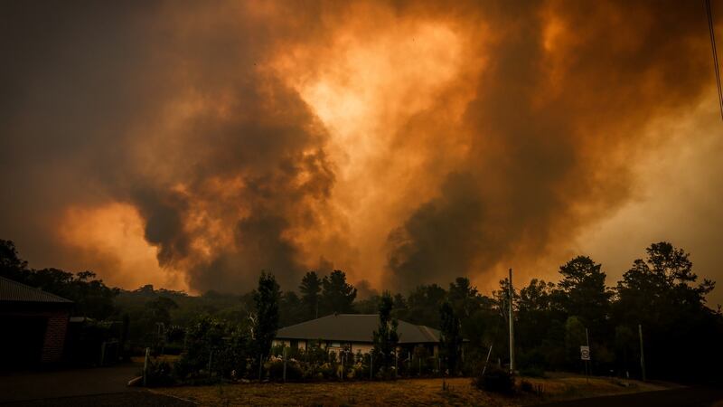 Two bushfires approach a home located on the outskirts of the town of Bargo  in Sydney, Australia. Photograph:  David Gray/Getty Images