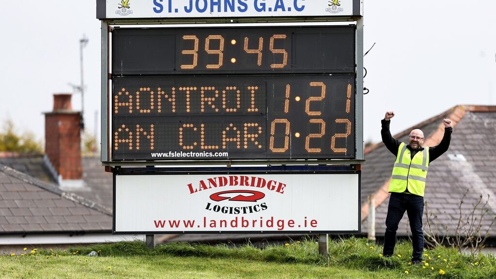 Steward Conor McCaffrey celebrates next to the scoreboard after Antrim’s shock win at Corrigan Park. Photograph: Laszlo Geczo/Inpho