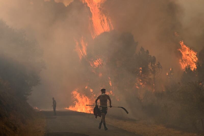 A man runs out of the flames during a wildfire near the village of Larouco, in the province of Ourense, in northwestern Spain earlier this week. Photograph: Miguel Riopa/AFP 