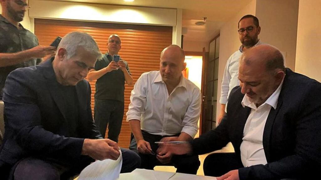 Head of the Arab Israeli Islamic conservative party Raam Mansour Abbas (right) signing a coalition agreement with Israel’s opposition leader Yair Lapid (left) and right-wing nationalist tech millionaire Naftali Bennett in Ramat Gan near Tel Aviv. Photograph: United Arab List Raam/AFP via Getty