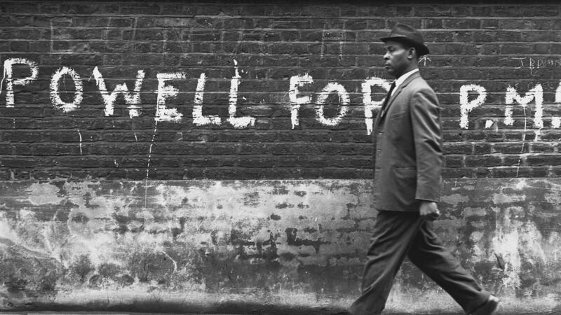 A  man walks past graffiti in support of Enoch Powell. Photograph:  Hulton-Deutsch Collection//Corbis via Getty Images