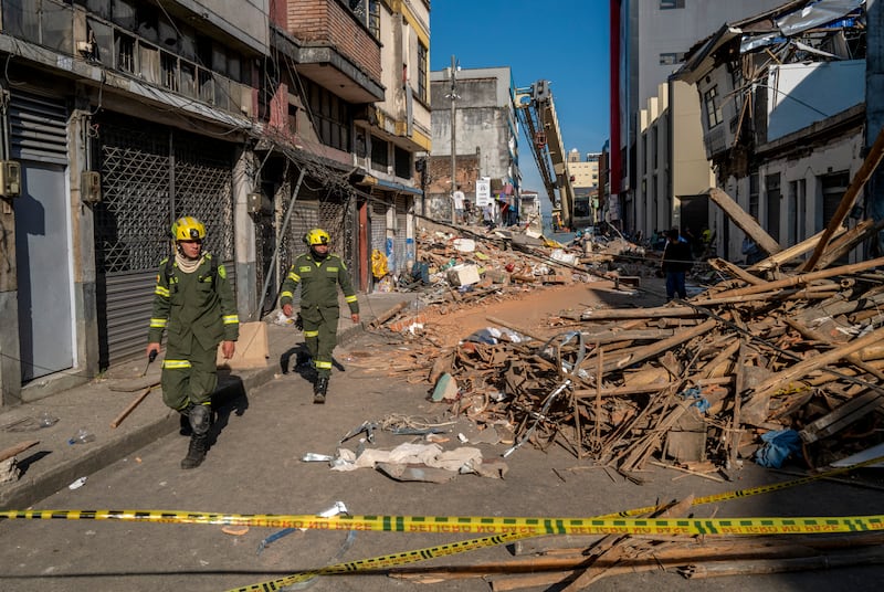 First responders walk down a rubble-strewn street in Pereira, Colombia. Photograph: Juan Arredondo/New York Times