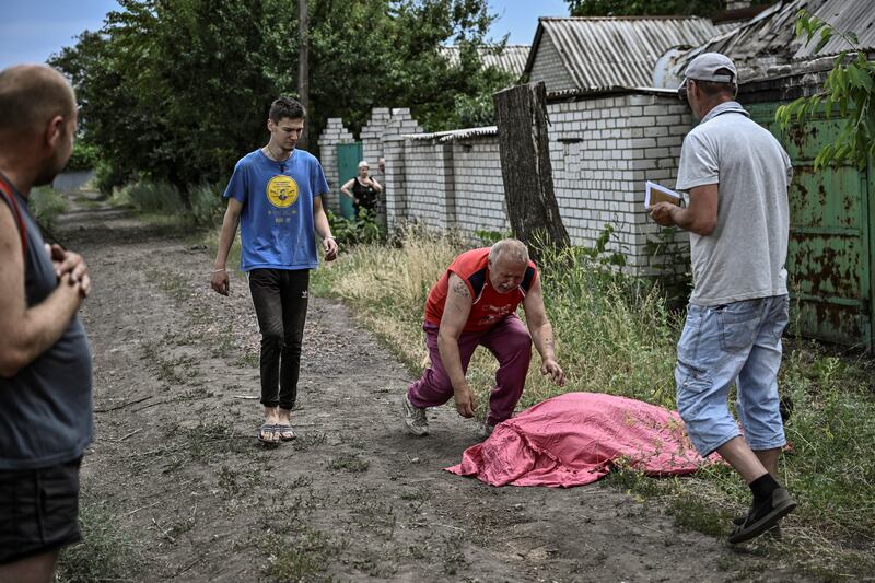A man approaches the body of his son who was reportedly killed by a cluster rocket in the city of Lysychansk, eastern Ukraine. Photograph: Aris Messinis/AFP via Getty Images