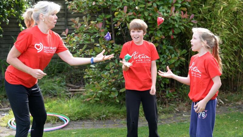 Sheila O’Sullivan who works with the Irish Heart Foundation and trains primary-school teachers in PE teaching, exercises with Katie and Frankie O’Sullivan. Photograph: Dara Mac Dónaill