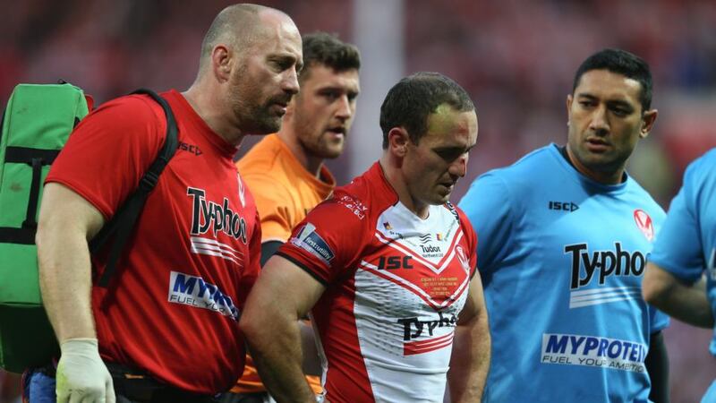 Lance Hohaia (centre) of St Helens is helped off the field by medics after being punched by Ben Flower of Wigan. Photograph:  Michael Steele/Getty Images