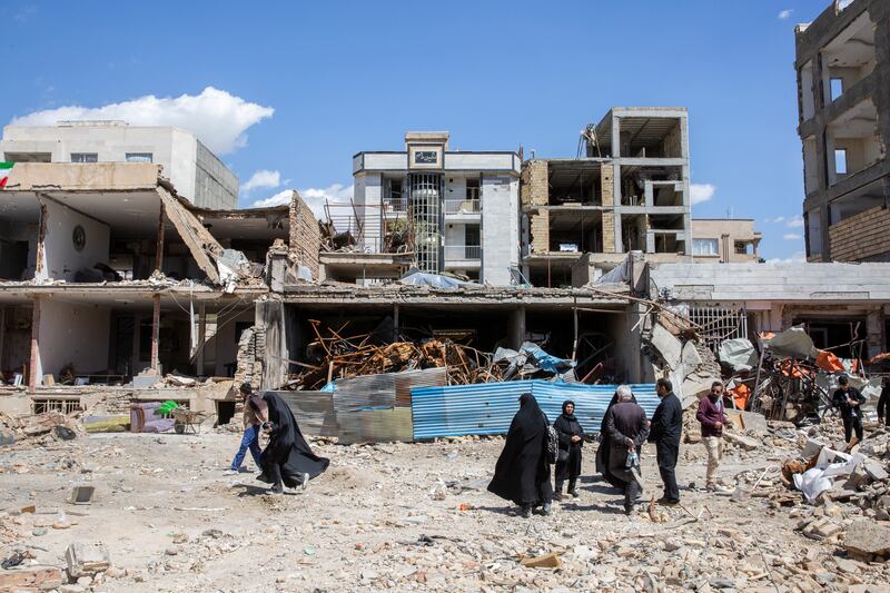 
                        People gather by residential buildings after a neighborhood was targeted by airstrikes in Karaj, Iran, on Friday, April 3th. (Arash Khamooshi/The New York Times)
                      