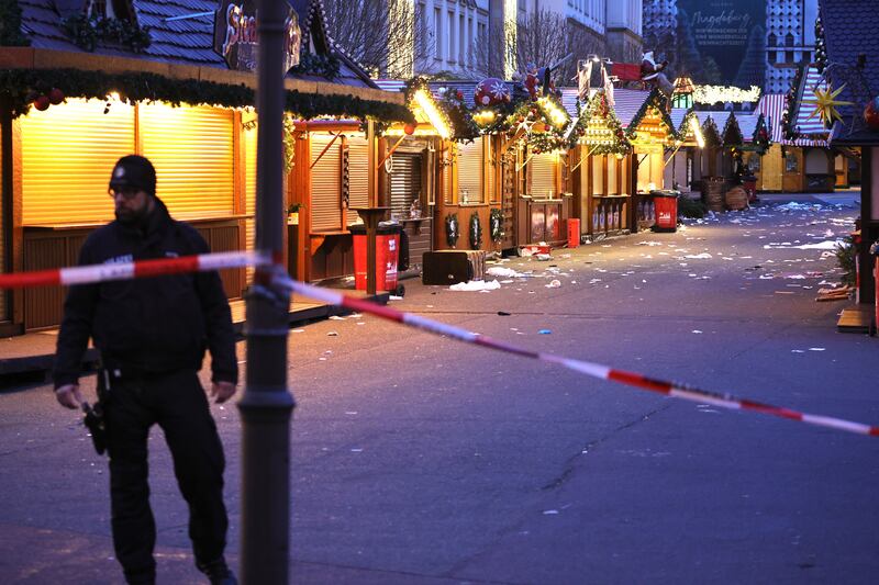 A policeman walks through the shuttered Christmas market the day after the attack. Photograph: Omer Messinger/Getty Images