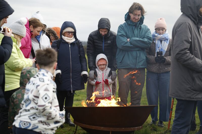 Warming hands at an open fire at Uisneach. Photograph: Nick Bradshaw/The Irish Times
