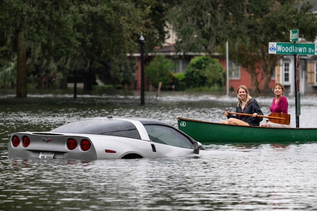 People paddle by in a canoe next to a submerged Chevy Corvette in the aftermath of Hurricane Ian in Orlando, Florida on Thursday. Photograph: Jim Watson/AFP