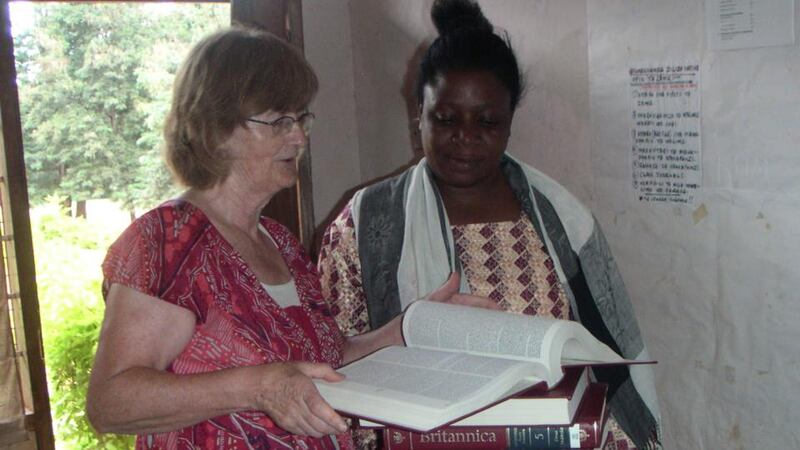 Tanzania: retired student adviser Ros McFeely donating books from Ireland to a librarian at Lupanga Secondary School