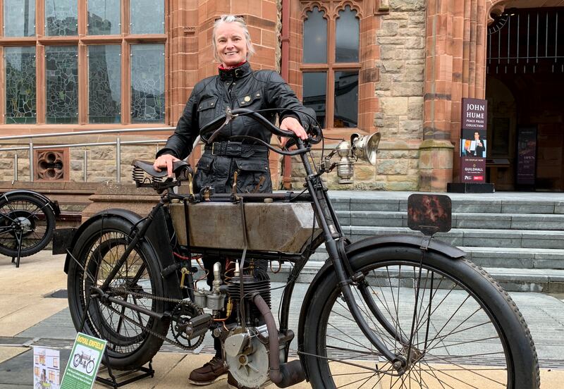JP Burney’s great granddaughter Julie Horne outside Derry's Guildhall with a 1904 Royal Enfield motorcycle similar to the one he rode 120 years ago to win the world's first motorcycle road race. Photograph: Peter Murtagh