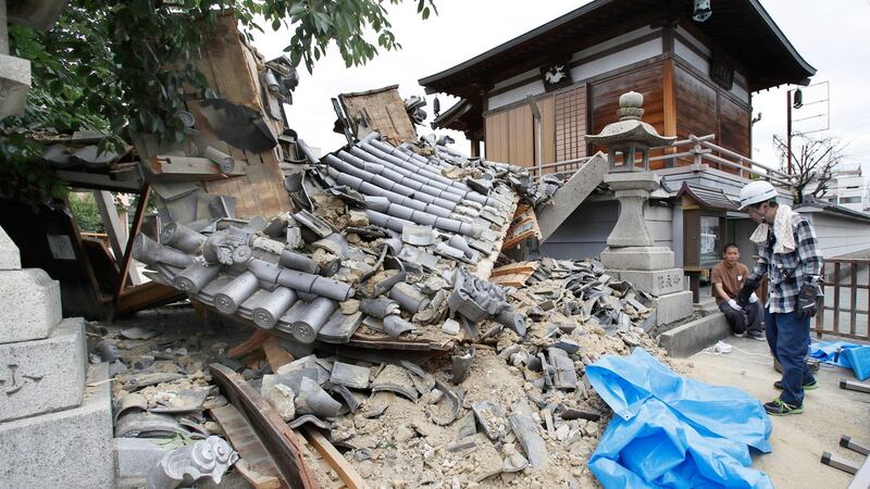 The gate of Myotoku-ji temple collapses after an earthquake hit Ibaraki City, Osaka. Photograph:Yosuke Mizuno/Kyodo News via AP