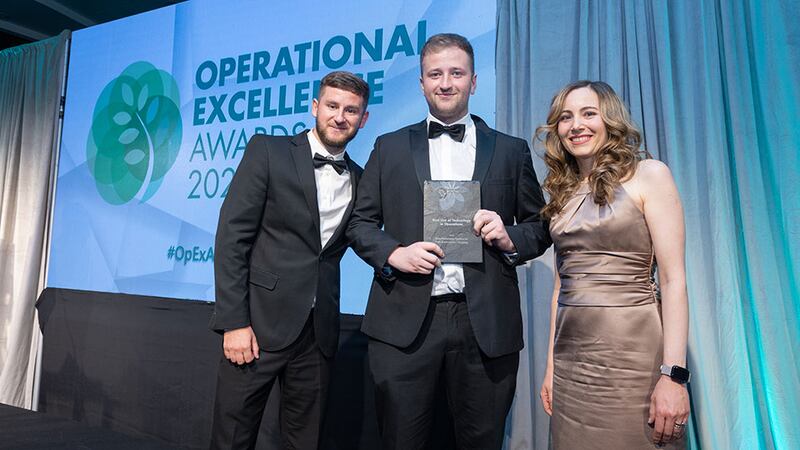 Adam Kane, senior sales executive at Business River, presents the best use of technology in operations award to Aidan Wickham and Gonca Ersahin, Fastway