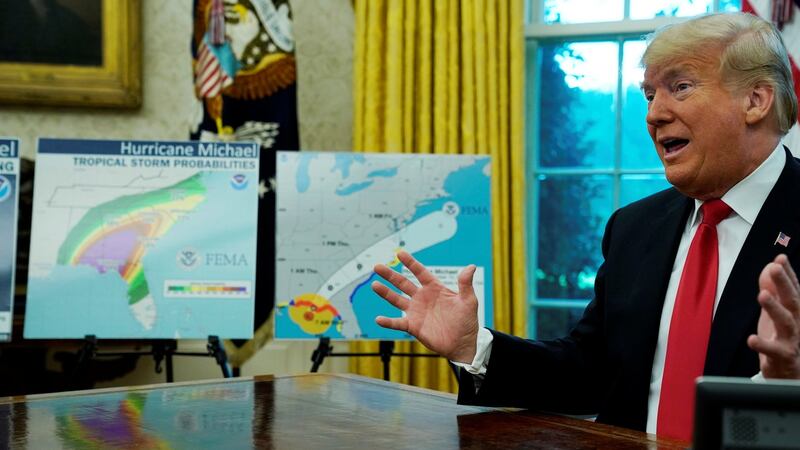 US President Donald Trump talks about Hurricane Michael next to maps and projections on the storm during a meeting in the Oval Office at the White House in Washington on Wednesday. Photograph:  Jonathan Ernst/Reuters