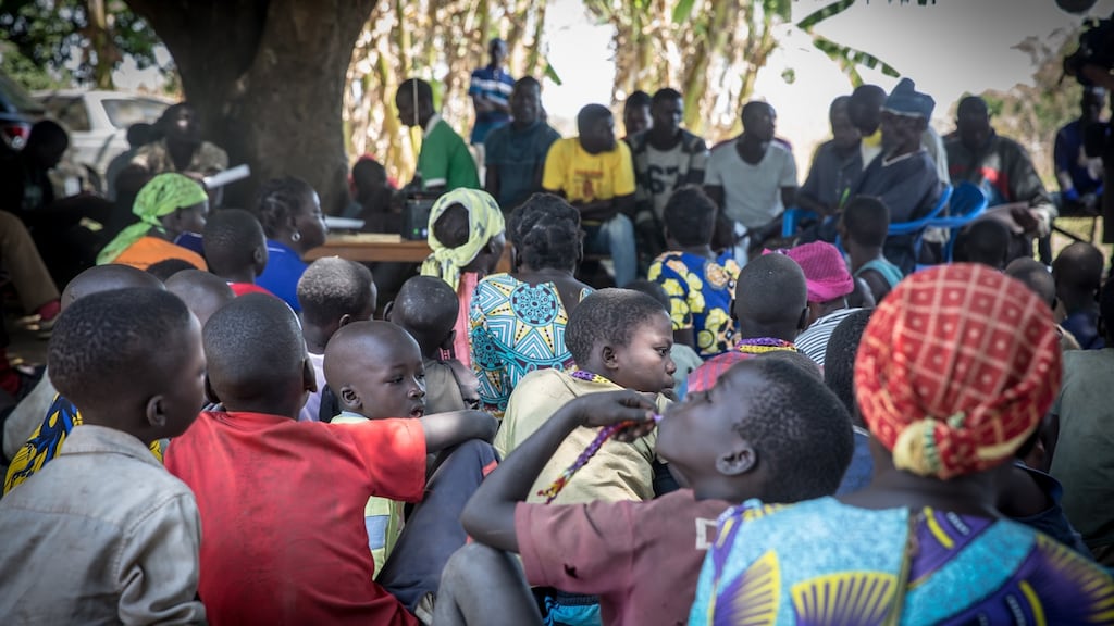 Young boys listen to a radio broadcasting the verdict in the ruling against Dominic Ongwen, a former LRA commander, in his home village of Coorom, northern Uganda. Photograph: Sally Hayden