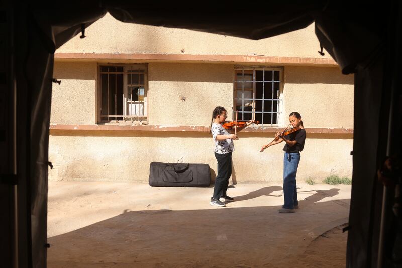 Displaced Palestinian girls practice and play the violin as part of a music education programme within the Edward Said National Conservatory of Music’s tented learning centre in Gaza City. Photograph: AFP via Getty Images