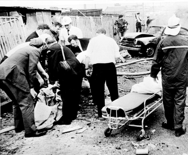 Rescue workers lift a body after one of the explosions on Bloody Friday. Photograph: PA 