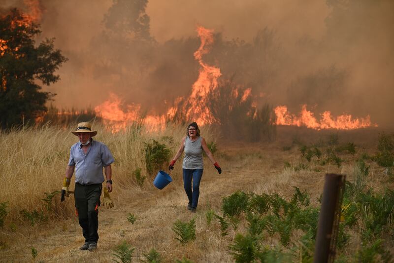 People try to battle a wildfire in the village of Santa Baia de Montes in the province of Ourense, northwestern Spain, this week. Photograph: Miguel Riopa/AFP 