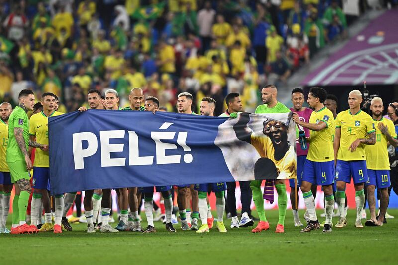 Brazil players stand behind a banner honouring Brazilian football legend Pele. Photograph: Manan Vatysyayana/AFP via Getty