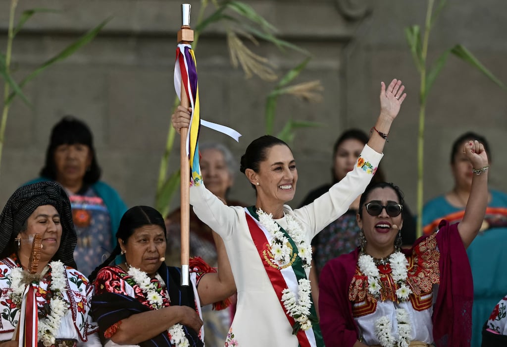 Mexico's new President Claudia Sheinbaum raises the ceremonial staff she received from indigenous peoples at the Zocalo Square in Mexico City on October 1, 2024. (Photo by CARL DE SOUZA / AFP) (Photo by CARL DE SOUZA/AFP via Getty Images)