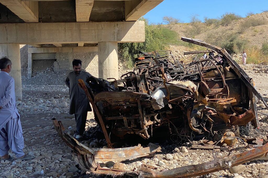 Residents look at the wreckage of a burnt passenger bus in Lasbela district of Pakistan's Balochistan province. Photograph: Ismail Sasoli/Getty Images