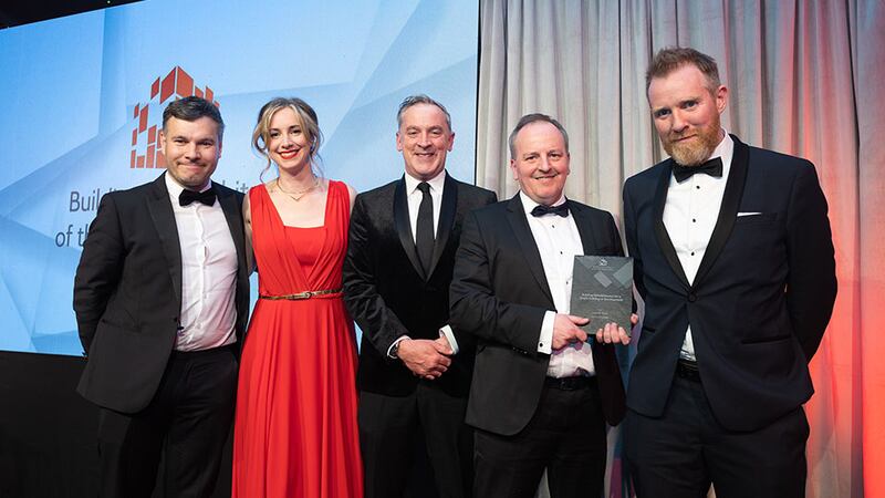 Barry Hennessy, business development and marketing director, Walls Construction, presents the building refurbishment for a single building or development award to the Henry J Lyons team