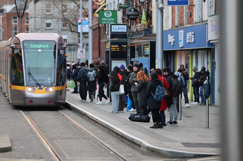 People wait for a Luas to stop on Parnell Street, Dublin 1. Photograph: Dara Mac Dónaill 





