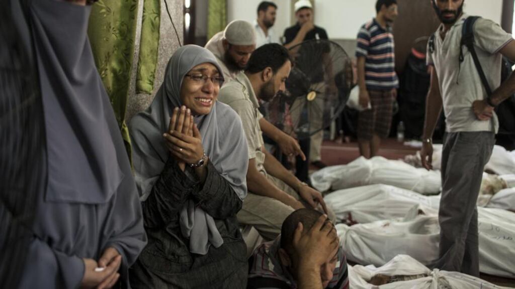 An Egyptian woman identifies the body of a family member, a supporter of deposed Egyptian president Mohamed Morsi killed during a violent crackdown by Egyptian security forces. In retaliation, Muslim Brotherhood supporters yesterday torched government buildings and clashed with security forces across the country. Photograph: Ed Giles/Getty Images
