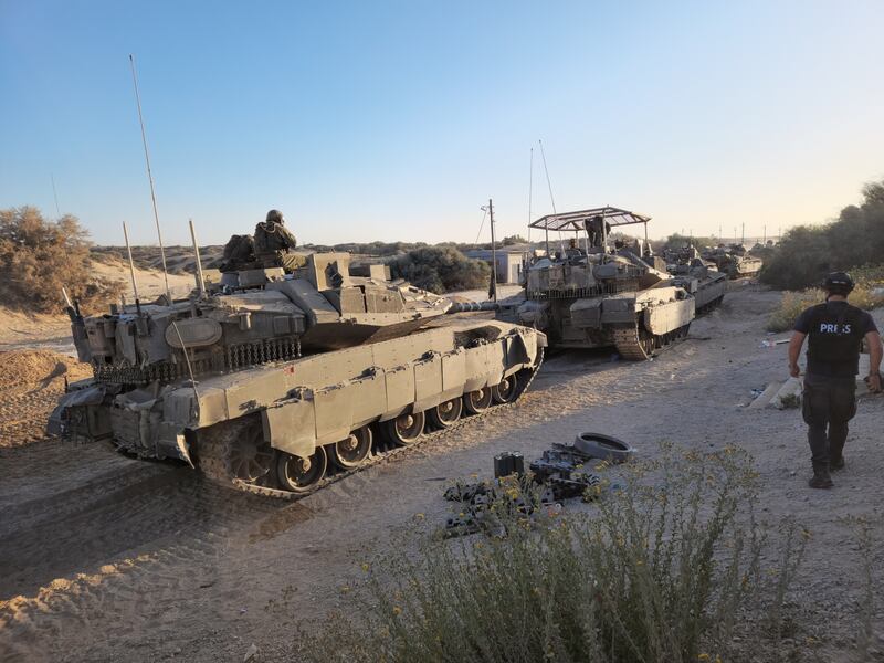 A member of the press walks by Israeli tanks in the Gaza Strip. Photograph: Ronen Bergman/The New York Times 