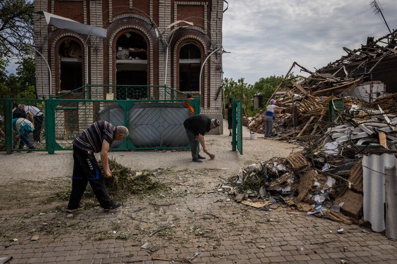 Local residents and parishioners clear debris around a Baptist church after a Russian missile strike in Druzhkivka, Ukraine. Photograph: Ivor Prickett/The New York Times