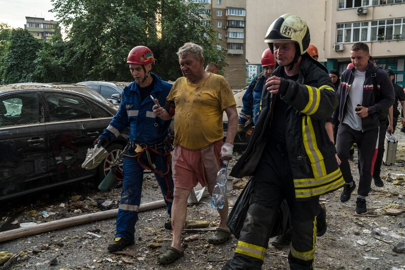 Rescue workers escort a man from a high-rise residential building in Kyiv. Photograph: Brendan Hoffman/The New York Times
