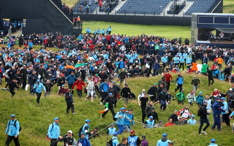 Fans run towards the 18th green to celebrate during the final round of the 2019 Open in Royal Portrush. Photograph: Francois Nel/Getty Images