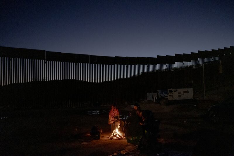 People from Guatemala and Mexico wait for border patrol officers to show up at a camp next to the Mexican border wall in Sásabe, Arizona, on Wednesday. Photograph: Fred Ramos/New York Times
                      