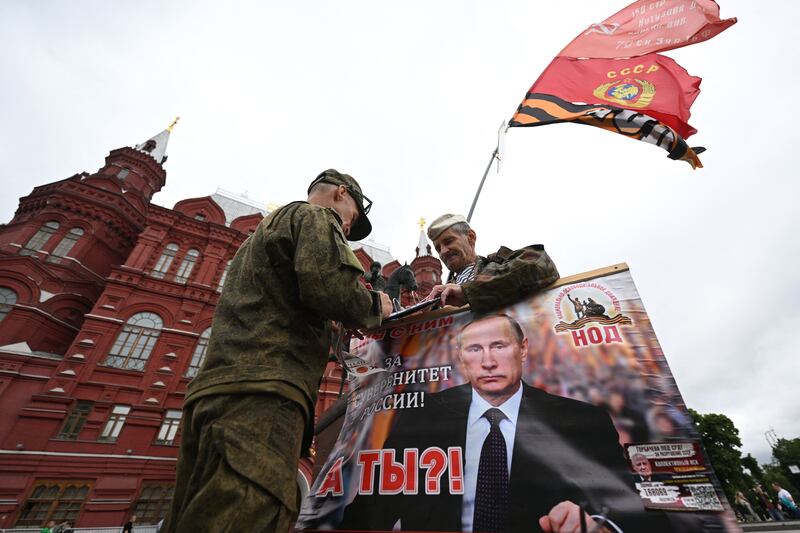 Activists hold a portrait of President Vladimir Putin near Red Square in Moscow Saturday. Residents have been told to refrain from trips around the city. Photograph: Natalia Kolesnikova/AFP/Getty