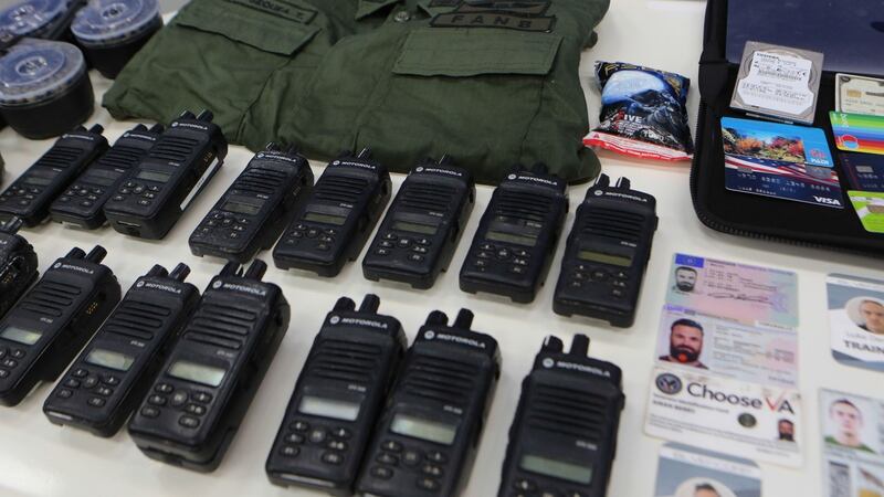 Identification cards, two-way radios and other military gear allegedly seized from US citizens arrested by Venezuelan security forces during a meeting with members of the Bolivarian National Armed Forces  at Miraflores presidential palace in Caracas on Monday. Photograph: Marcelo Garcia/Venezuelan presidency/AFP via Getty Images