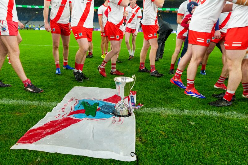 An Ghaeltacht players placed the trophy on the club flag after beating Glenullin in the All-Ireland Club Intermediate Football Championship final at Croke Park on Sunday. Photograph: James Lawlor/Inpho 