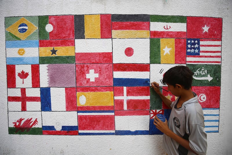 An artist in Karachi, Pakistan paints flags of participating nations on a wall ahead of the World Cup Qatar 2022. The event will take place from November 20th to December 18th. 