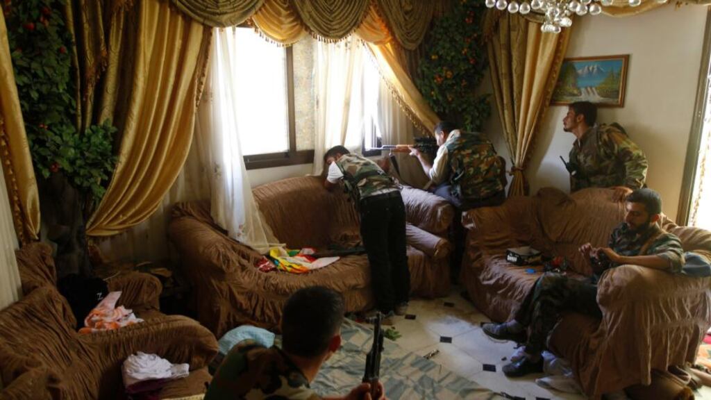 A Free Syrian Army fighter fires his sniper rifle from a house in Aleppo on August 14th, 2012. Photograph: Reuters