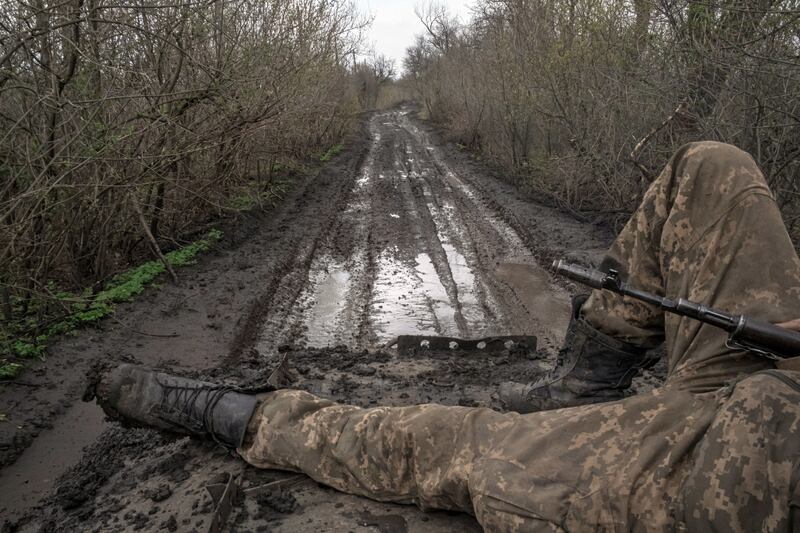 A Ukrainian soldier reclines on top of an  personnel carrier as he is transported to a front line position near the fiercely contested city of Bakhmut. Photograph: Mauricio Lima/New York Times
                      