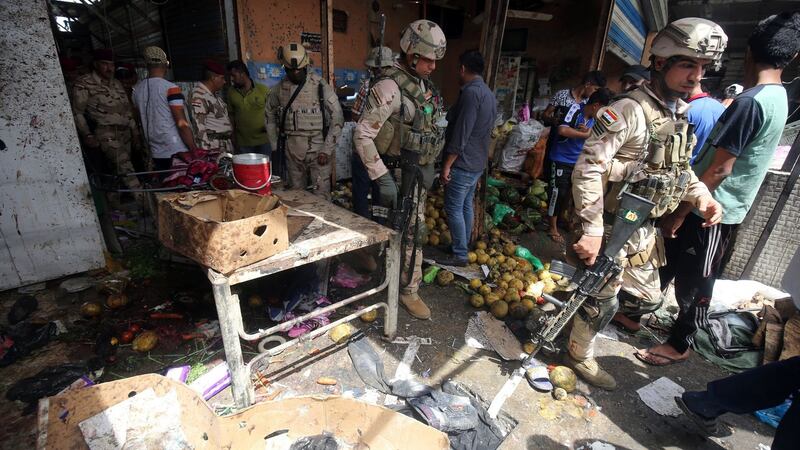Iraqi security forces gather at the site of a suicide bombing in the Shaab area in northern Baghdad on Tuesday. Interior ministry spokesman Saad Maan said the attack was carried out by a female suicide bomber, while a police colonel said a roadside bombing was followed by the suicide attack. Photograph: Ahmad Al-Rubayeah/Getty Images