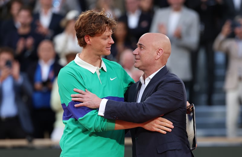 Jannik Sinner receives his runner-up trophy ceremony from Andre Agassi. Photograph: Clive Brunskill/Getty Images
