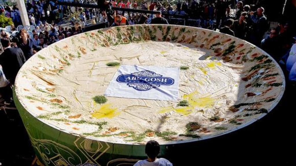 Israeli Arabs and Jews gather around a world record-breaking 4,090kg dish of hummus in the Arab town of Abu Ghosh, outside Jerusalem, yesterday. Israel beat the Lebanese record of 2,056kg, set in Beirut in October. Photograph: David Vaaknin/AP Photo