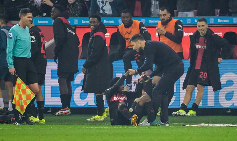 Bayer Leverkusen's Jeremie Frimpong is lifted by head coach Xabi Alonso and celebrated by team-mates after scoring the 3-0 goal against Bayern Munich. Photograph: Sascha Schuermann/Getty Images