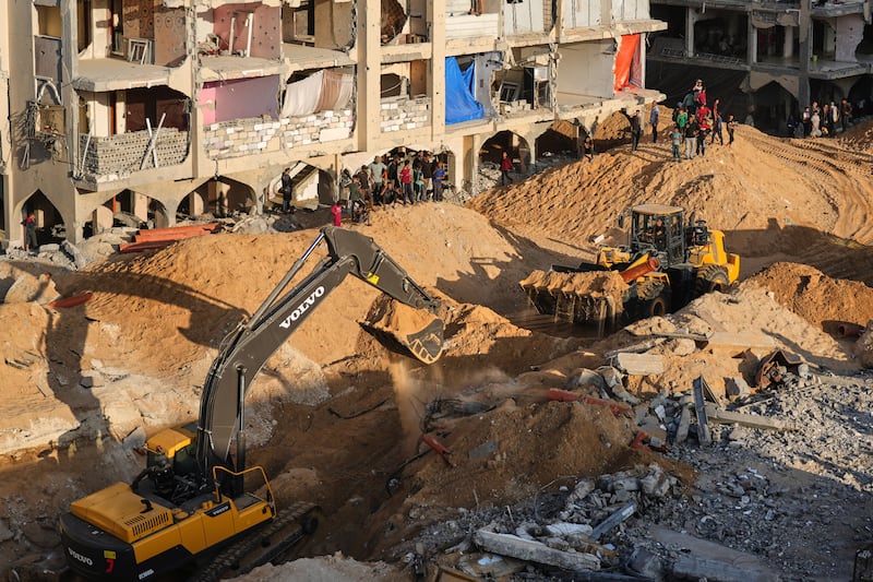 Palestinians watch machinery and some workers from Egypt searching for the bodies of hostages at Hamad City. Photograph: Jehad Alshrafi/AP