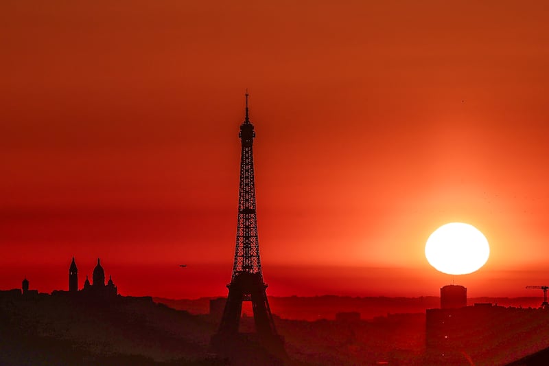 The sun rises by the Eiffel Tower and the Sacre Coeur Basilica on top of the Montmartre hill in Paris on Tuesday, as the city is on red alert for high temperatures, with the top of the Eiffel Tower shut, polluting traffic banned and speed restrictions in place as a searing heatwave gripped Europe. Scientists say human-induced climate change is making such heatwave events more intense, frequent and widespread. Photograph: Thibaud Moritz/AFP/Getty
