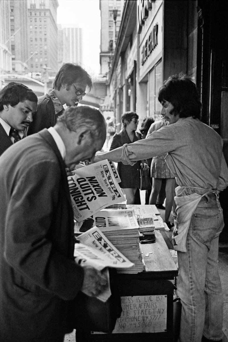 A newspaper vendor does a brisk business outside Grand Central Station in New York in  1974 as word spreads that President Richard M Nixon would announce his resignation later that night. Photgraph: Neal Boenzi/The New York Times